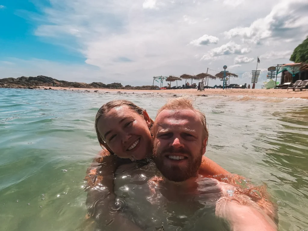 A couple swims in the calm clear water at Batheegama beach