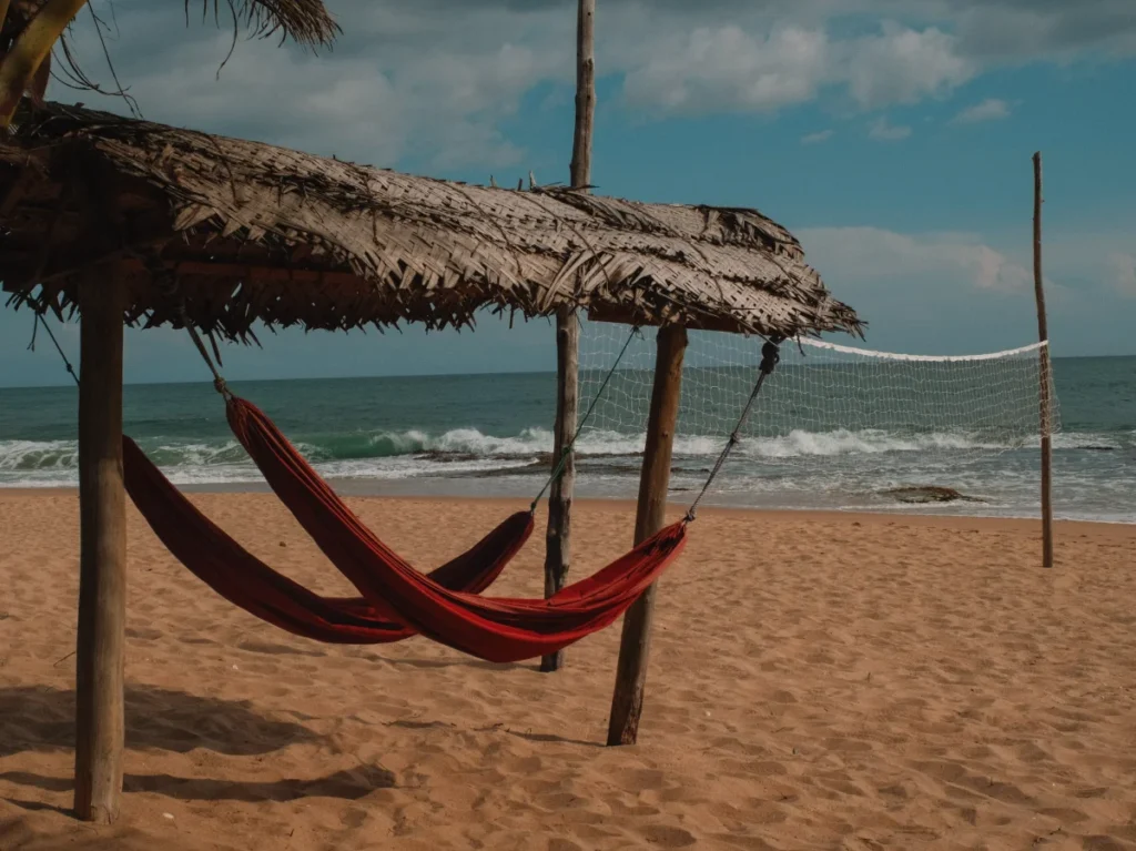 Two hammocks and a volleyball net on an empty Tangalle beach